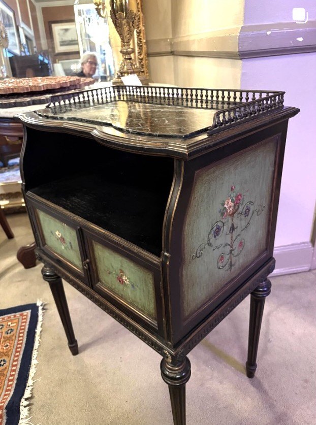 Black-lacquer side cabinet with hand-painted floral panels on slender tapered legs.